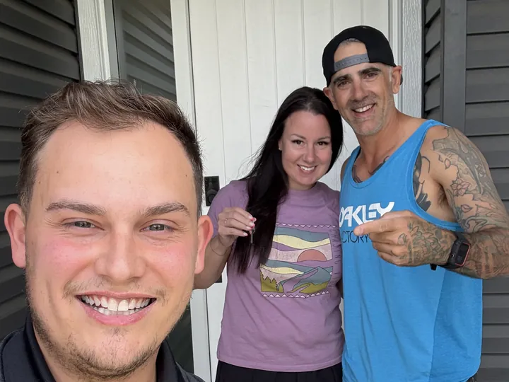 Amber T. and Nick with Cameron at their front door, keys in hand