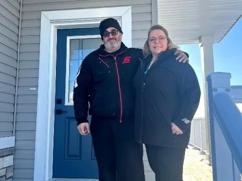 Joanne K. and her husband at their front door